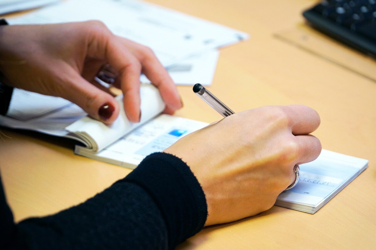 Stale dated cheques - photo of someone filling out a cheque